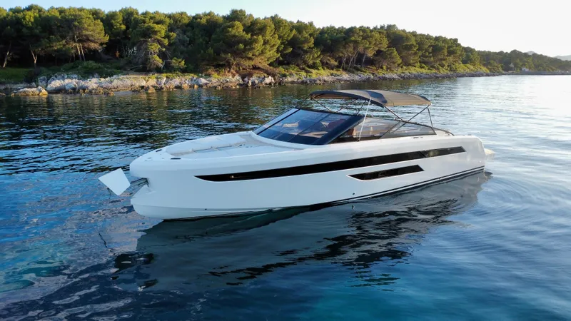 Ischia Yacht Photos Pics 2024 BB Yachts 44 Ischia luxury yacht on serene water near a forested shoreline.