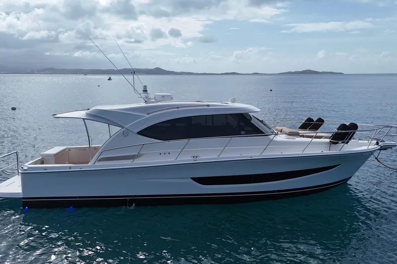  Yacht Photos Pics 2020 Riviera 395 SUV yacht on calm ocean waters under cloudy sky.