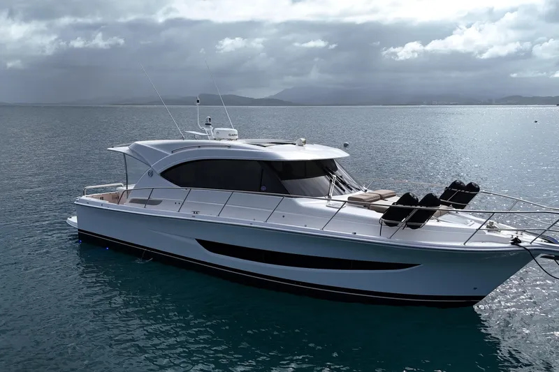  Yacht Photos Pics 2020 Riviera 395 SUV yacht on calm waters under cloudy skies.