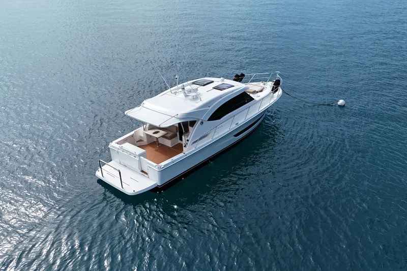  Yacht Photos Pics 2020 Riviera 395 SUV yacht anchored on calm blue water.