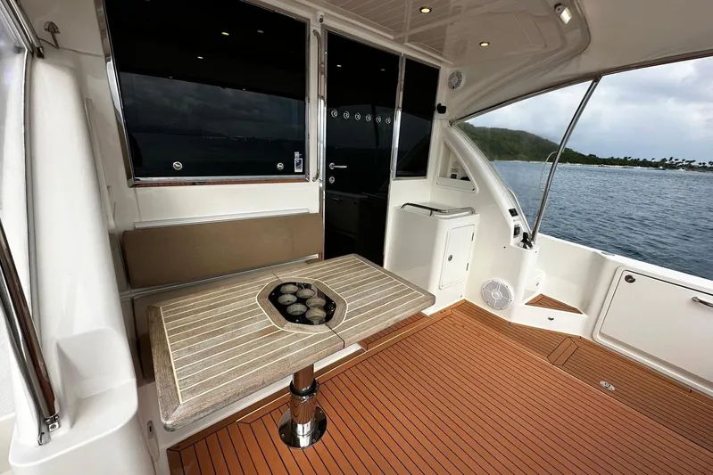  Yacht Photos Pics 2020 Riviera 395 SUV interior with elegant seating and table, overlooking serene waters.