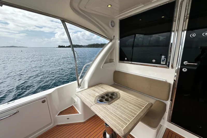  Yacht Photos Pics 2020 Riviera 395 SUV interior with seating and table, overlooking serene ocean view.