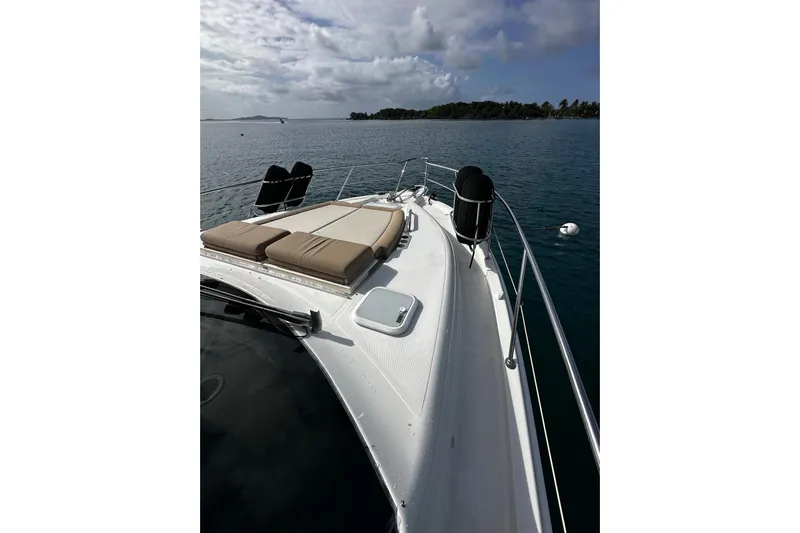  Yacht Photos Pics 2020 Riviera 395 SUV yacht deck with sun loungers, ocean view, and distant island.