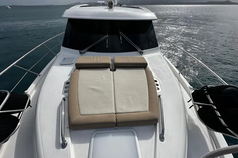  Yacht Photos Pics 2020 Riviera 395 SUV yacht with sunbed on deck, cruising on calm waters.