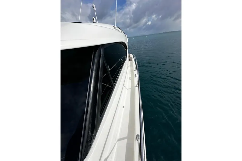  Yacht Photos Pics Side view of 2020 Riviera 395 SUV yacht on calm ocean waters.