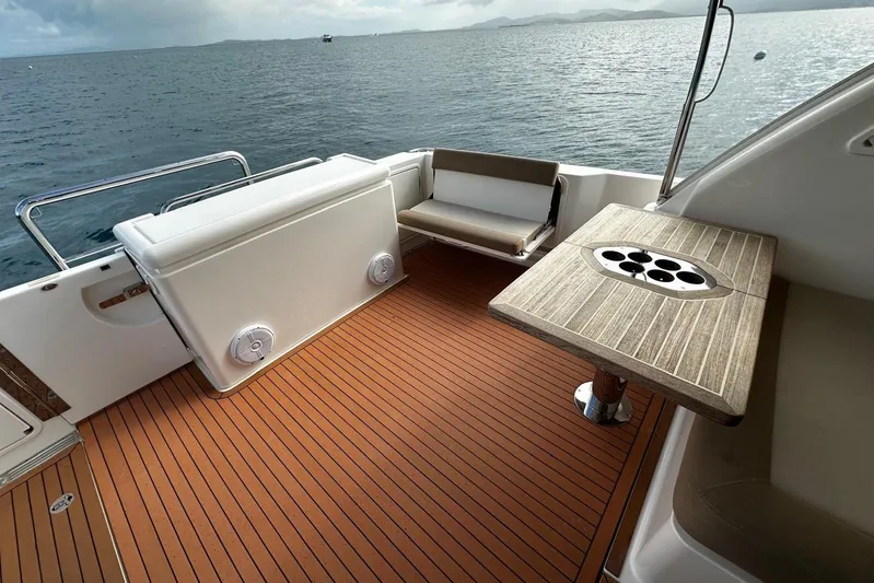  Yacht Photos Pics 2020 Riviera 395 SUV boat deck with seating and table, overlooking calm ocean waters.