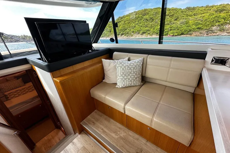  Yacht Photos Pics Interior of 2020 Riviera 395 SUV with beige seating, TV, and scenic window view.