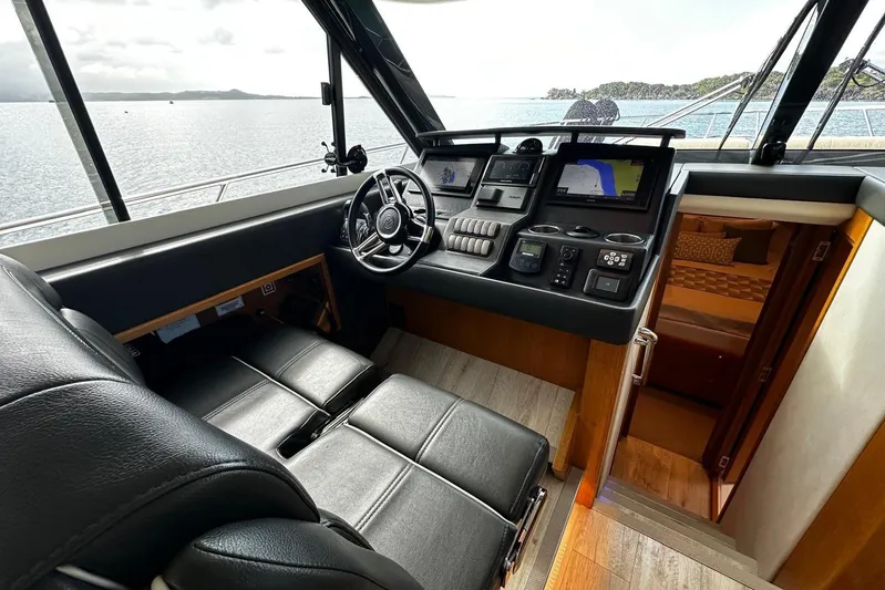  Yacht Photos Pics 2020 Riviera 395 SUV helm with leather seats, navigation screens, and ocean view.