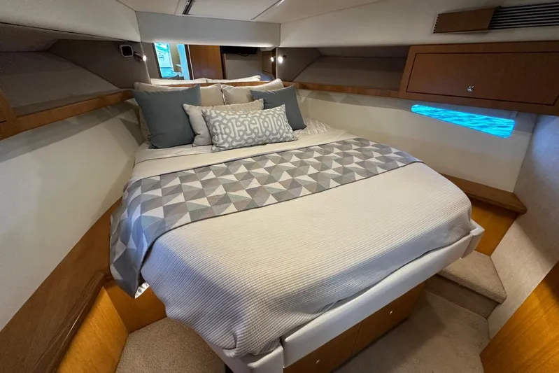  Yacht Photos Pics Luxurious bedroom interior of 2020 Riviera 395 SUV yacht with modern bedding and ambient lighting.