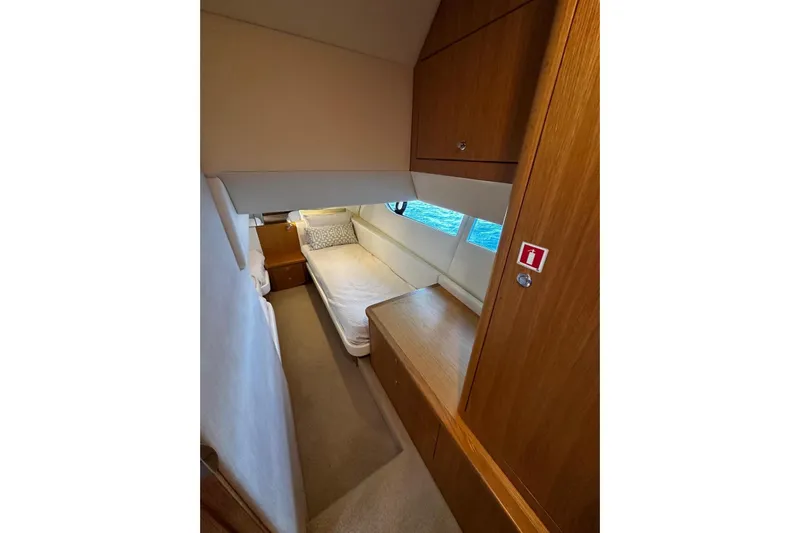  Yacht Photos Pics 2020 Riviera 395 SUV cabin interior with bed, wooden cabinetry, and window view.