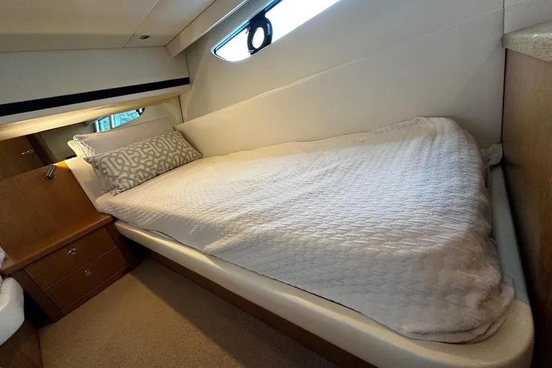  Yacht Photos Pics Cozy bedroom interior of 2020 Riviera 395 SUV yacht with elegant bedding and wooden accents.