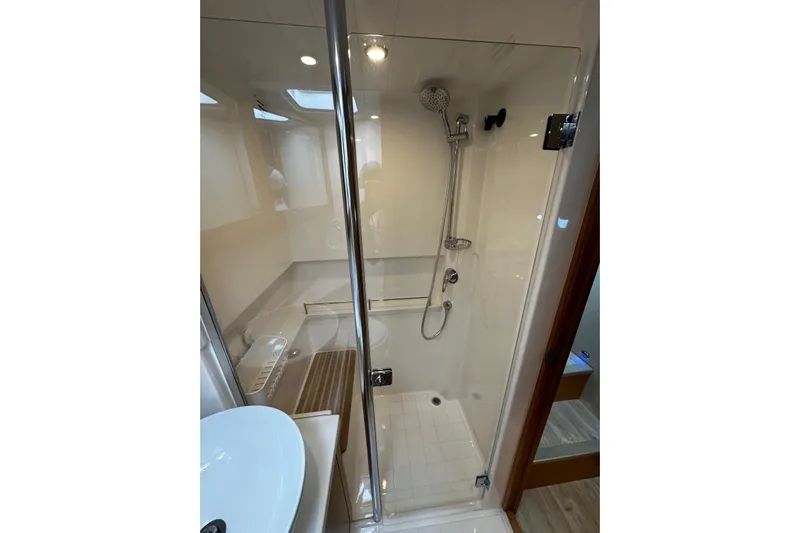  Yacht Photos Pics Modern shower in 2020 Riviera 395 SUV yacht, featuring sleek glass enclosure and chrome fixtures.