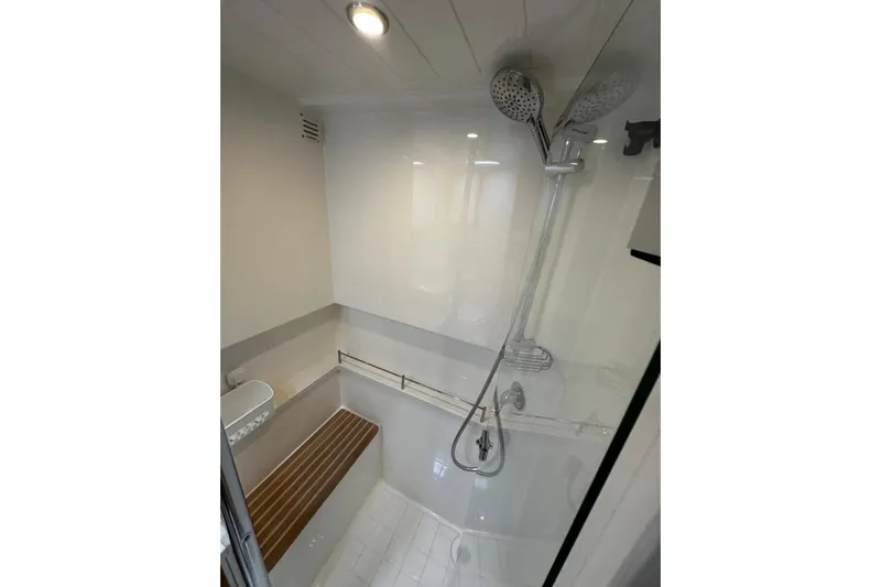 Yacht Photos Pics Modern shower area in 2020 Riviera 395 SUV yacht, featuring sleek fixtures and wooden bench.