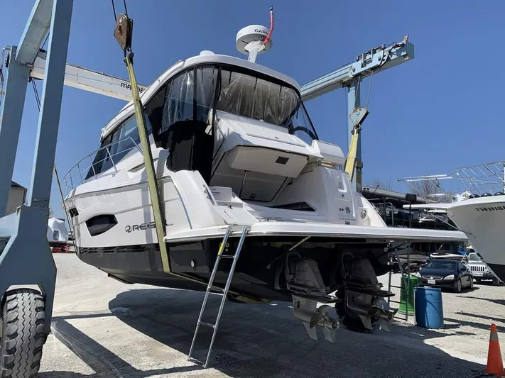  Yacht Photos Pics 2021 Regal 38 Grande Coupe yacht in dry dock, rear view with ladder and cranes.