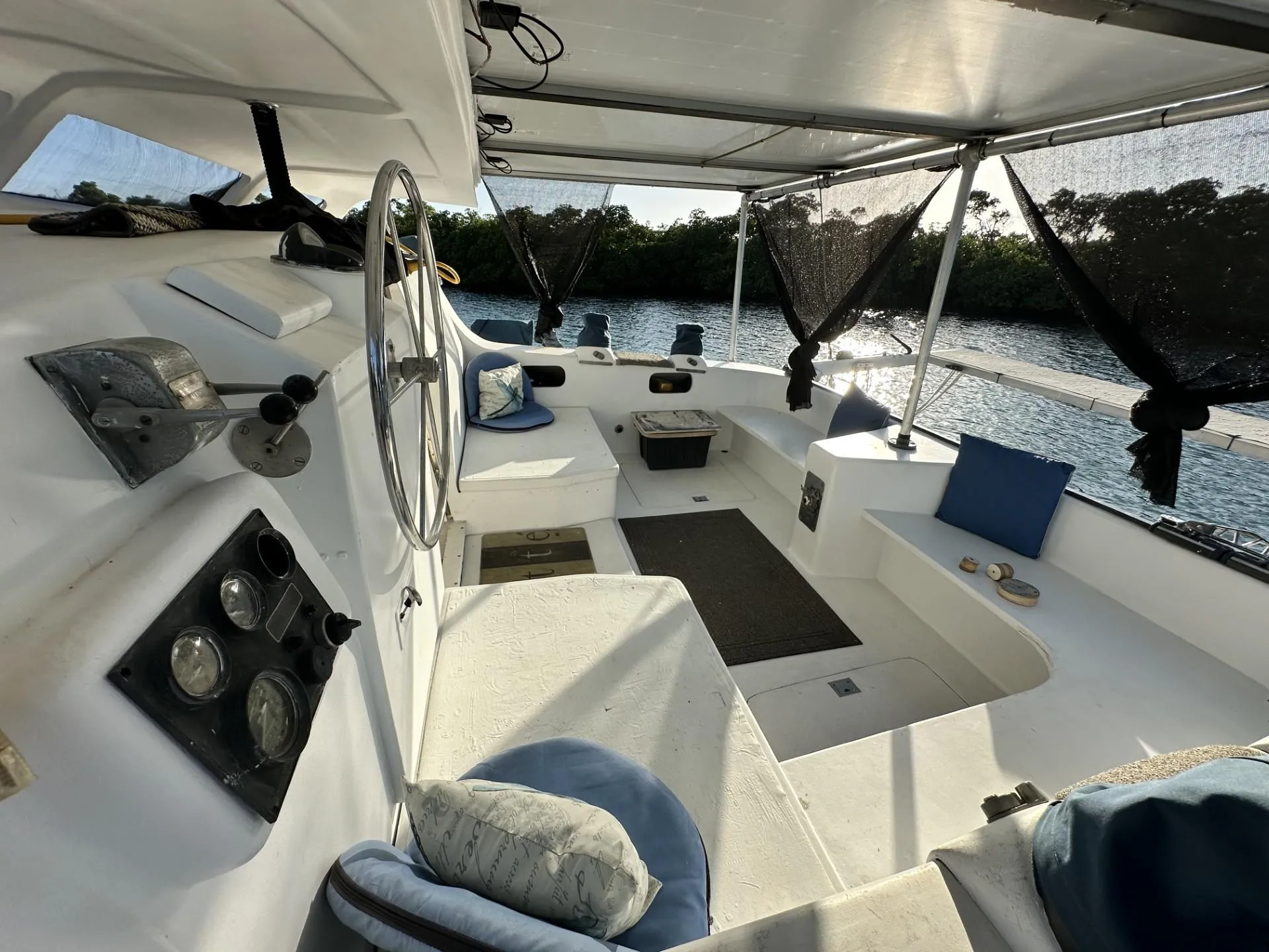 1972 Custom 53 Catamaran interior with steering wheel, seating, and scenic water view.