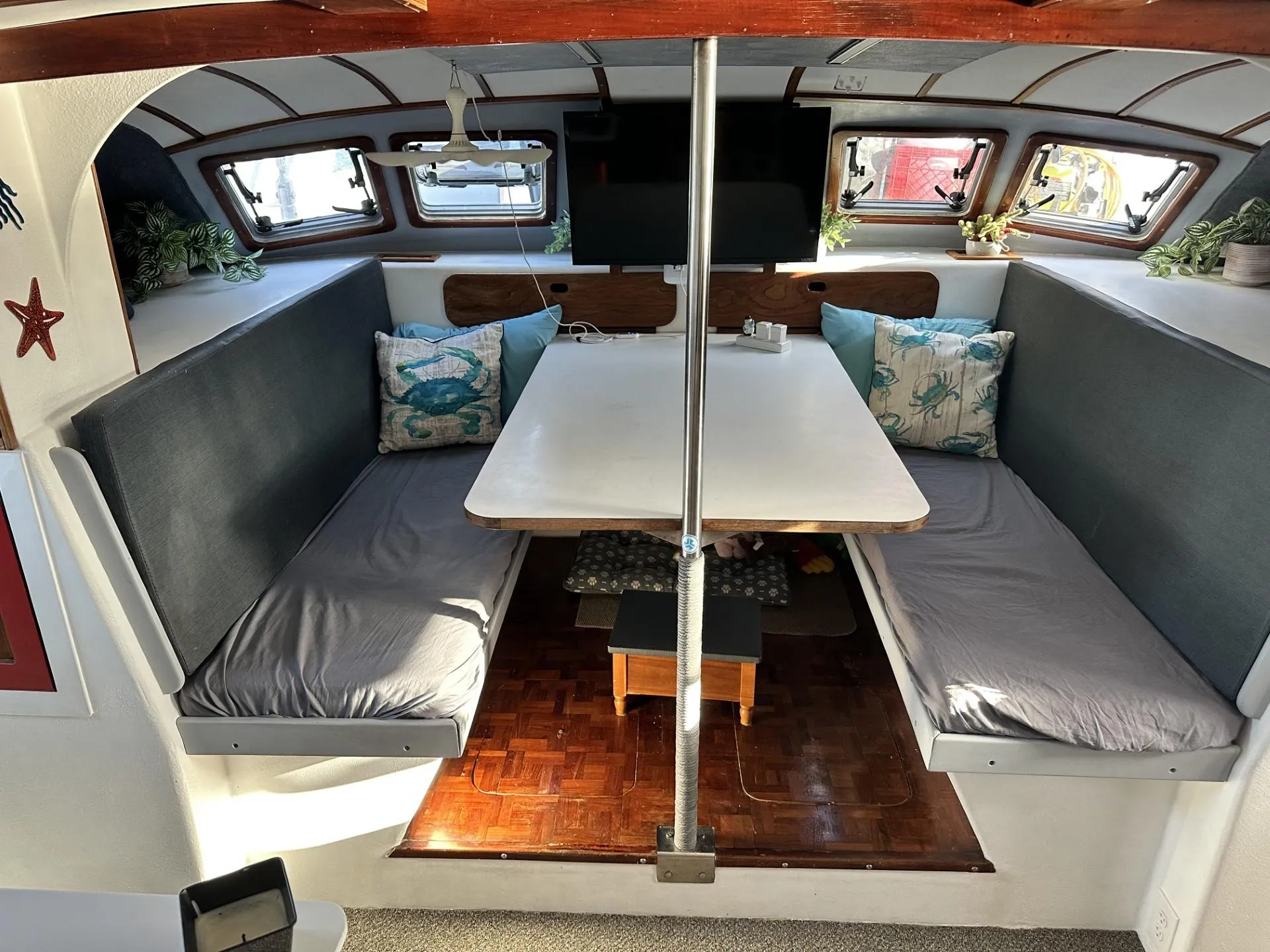 Interior of a 1972 Custom 53 Catamaran with cozy seating and a central table.
