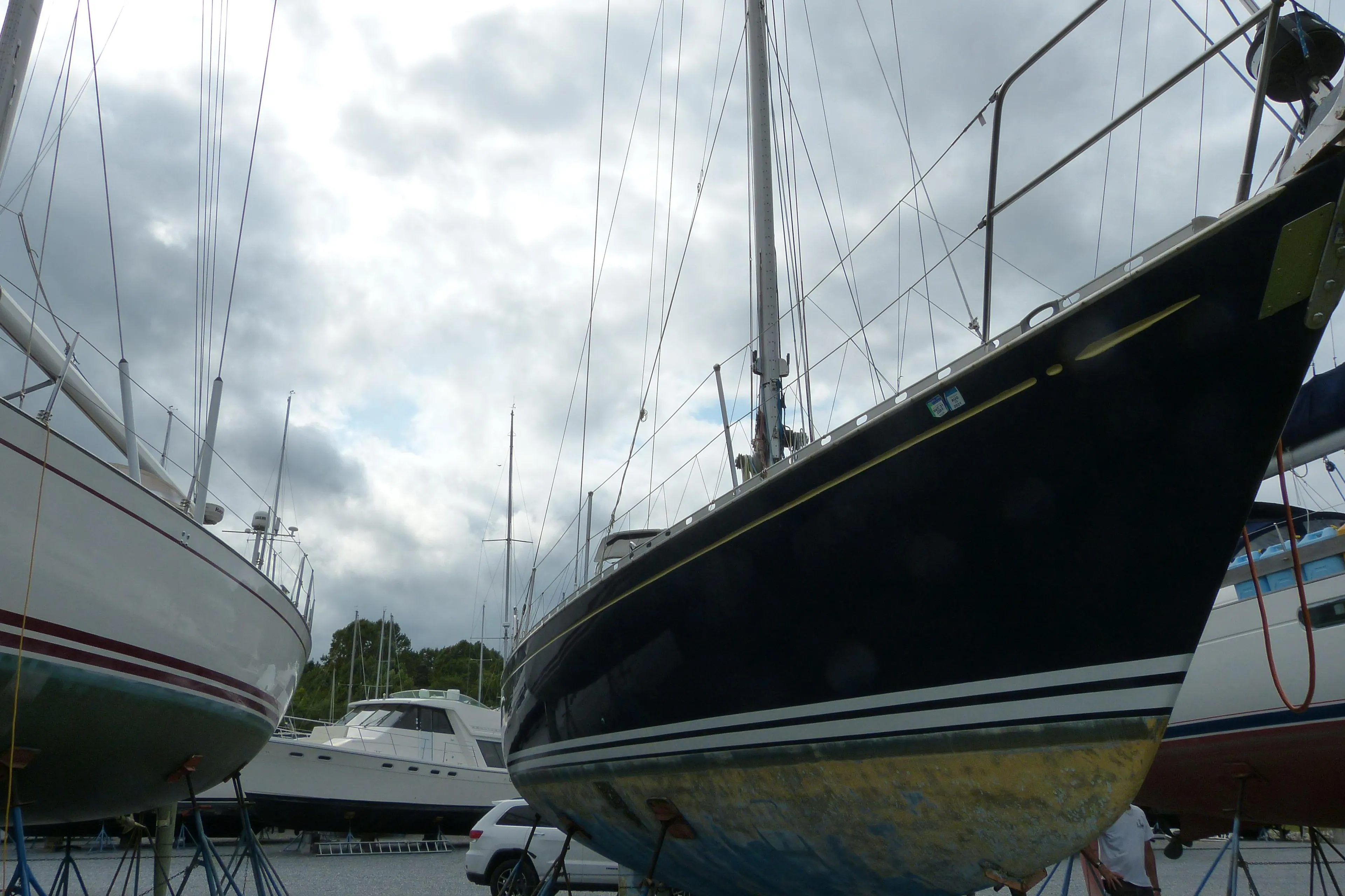 Hylas 44 sailboat from 1990 on stands, surrounded by other boats under a cloudy sky.