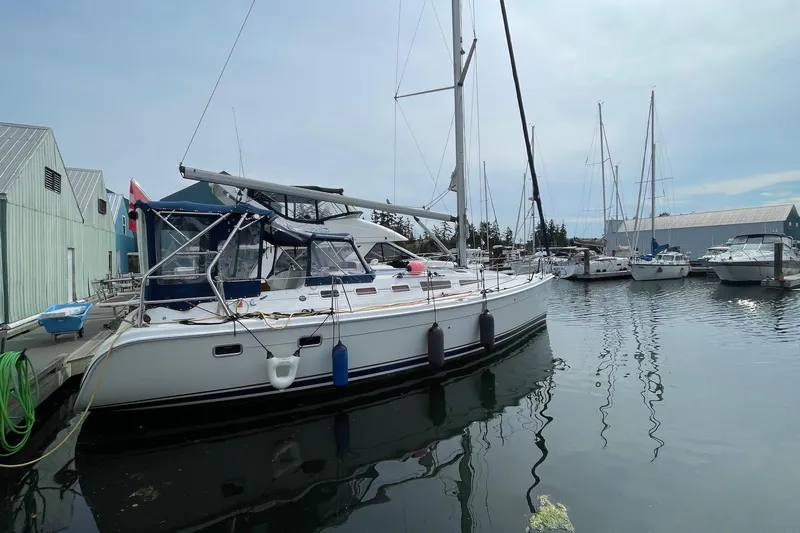  Yacht Photos Pics 2005 Hunter 38 sailboat docked at a marina, surrounded by other boats.
