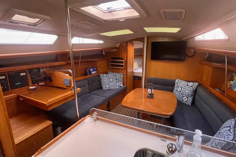  Yacht Photos Pics Interior of 2005 Hunter 38 sailboat with cozy seating and wooden finishes.