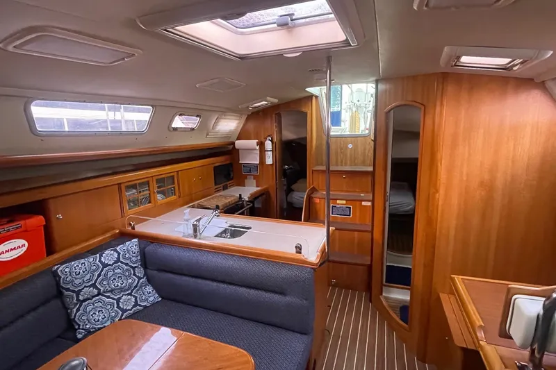  Yacht Photos Pics Interior of 2005 Hunter 38 sailboat with cozy seating and wooden cabinetry.
