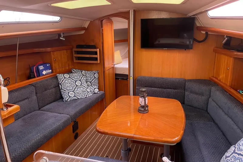  Yacht Photos Pics Cozy interior of 2005 Hunter 38 sailboat with seating, table, and TV.