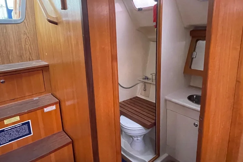  Yacht Photos Pics Interior of 2005 Hunter 38 sailboat showing compact bathroom with wooden accents.