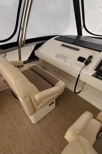 Never Again Yacht Photos Pics Interior helm of 2012 Sea Ray 450 Sedan Bridge with beige seating and control panel.