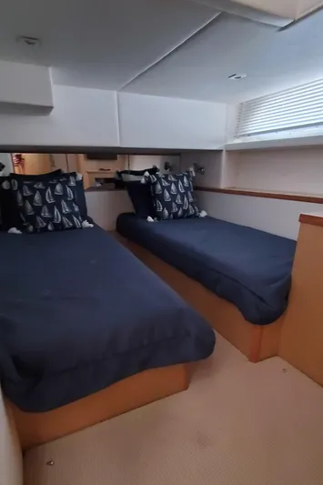 Never Again Yacht Photos Pics 2012 Sea Ray 450 Sedan Bridge cabin with twin beds and nautical-themed pillows.