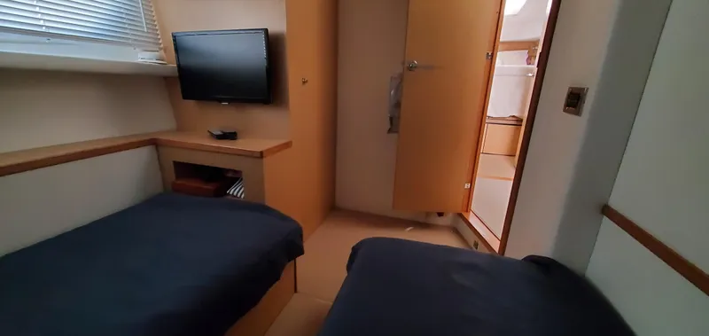 Never Again Yacht Photos Pics Twin cabin interior of 2012 Sea Ray 450 Sedan Bridge with TV and ensuite bathroom.