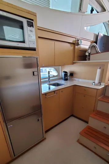 Never Again Yacht Photos Pics 2012 Sea Ray 450 Sedan Bridge kitchen with stainless appliances and modern cabinetry.