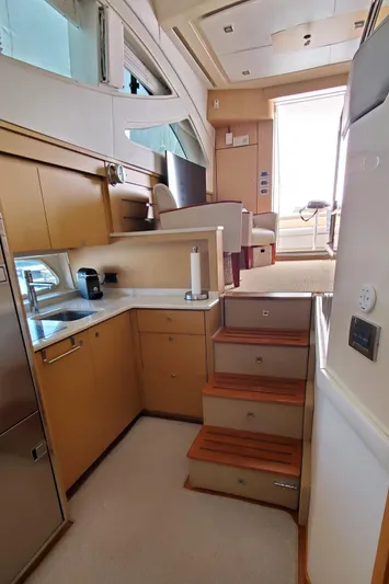 Never Again Yacht Photos Pics Interior of 2012 Sea Ray 450 Sedan Bridge yacht, featuring modern kitchen and wooden stairs.