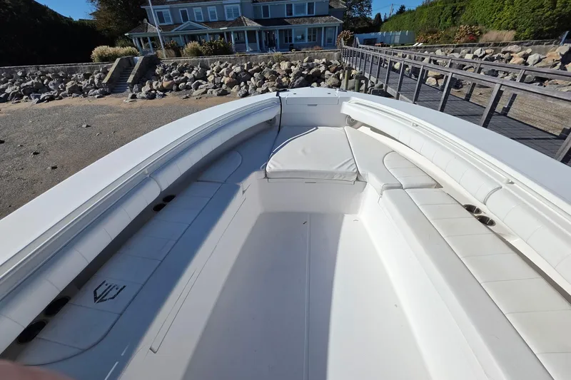  Yacht Photos Pics 2014 Regulator 34 boat with spacious seating, docked near a coastal house.