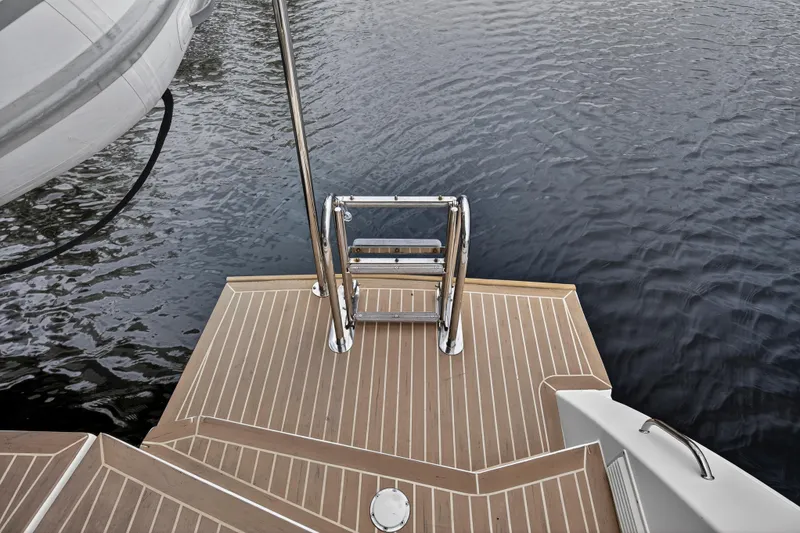 Sundecker Yacht Photos Pics Leopard 45 yacht swim platform with ladder, 2021 model, on calm water.