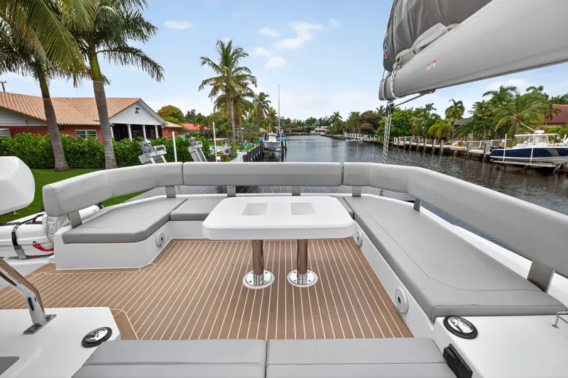 Sundecker Yacht Photos Pics Luxurious 2021 Leopard 45 yacht deck with seating, table, and scenic waterfront view.