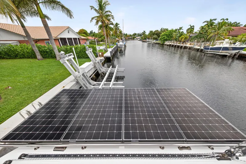 Sundecker Yacht Photos Pics Solar panels on a 2021 Leopard 45 catamaran docked by a scenic canal.