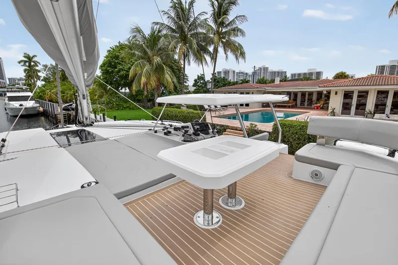 Sundecker Yacht Photos Pics Luxury Leopard 45 catamaran deck with seating, table, and tropical waterfront view.