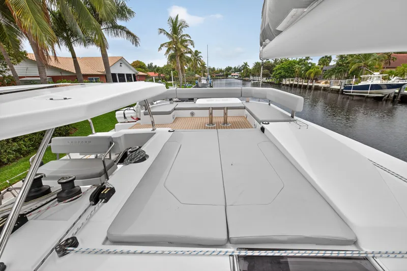 Sundecker Yacht Photos Pics Luxurious 2021 Leopard 45 catamaran with spacious deck, docked by a scenic canal.