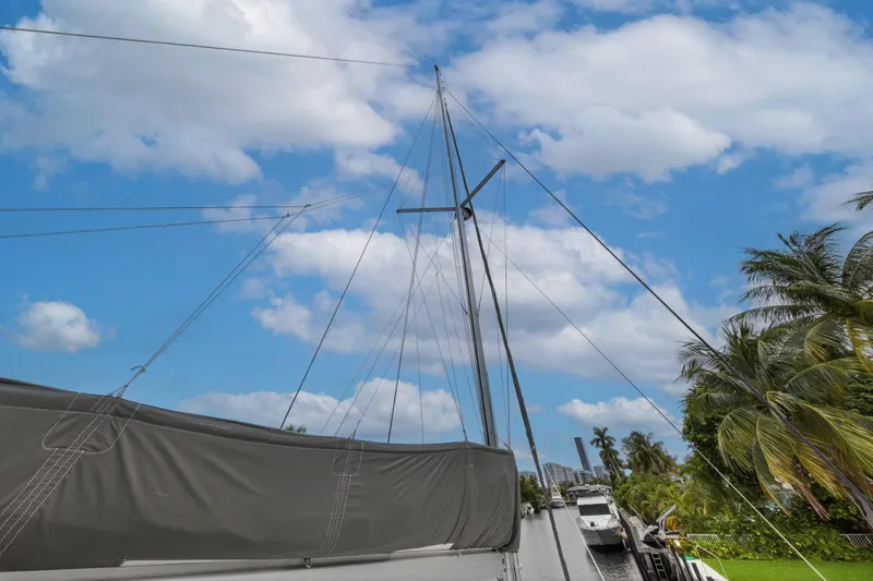 Sundecker Yacht Photos Pics Sailboat mast of 2021 Leopard 45 against blue sky and palm trees.