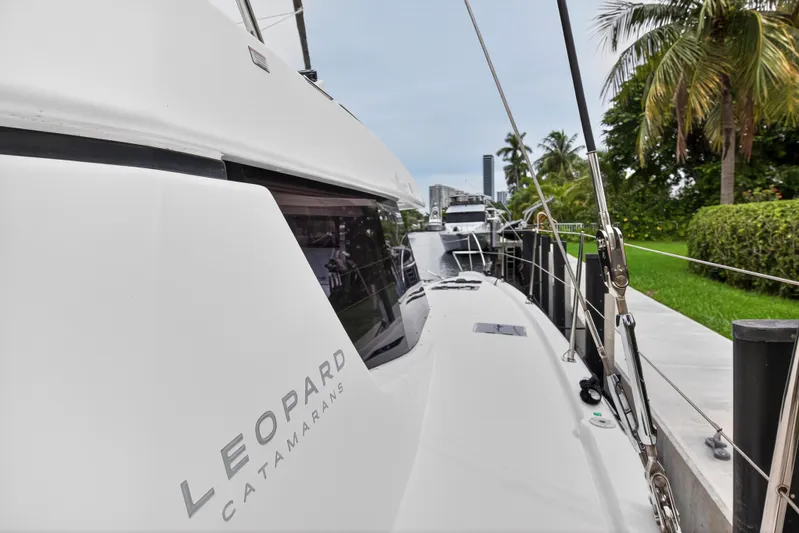 Sundecker Yacht Photos Pics Leopard 45 catamaran docked near palm trees, showcasing sleek design, 2021 model.