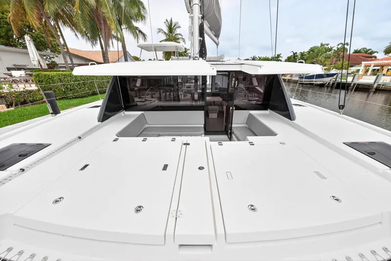 Sundecker Yacht Photos Pics 2021 Leopard 45 catamaran deck with sleek design, docked near tropical palm trees.