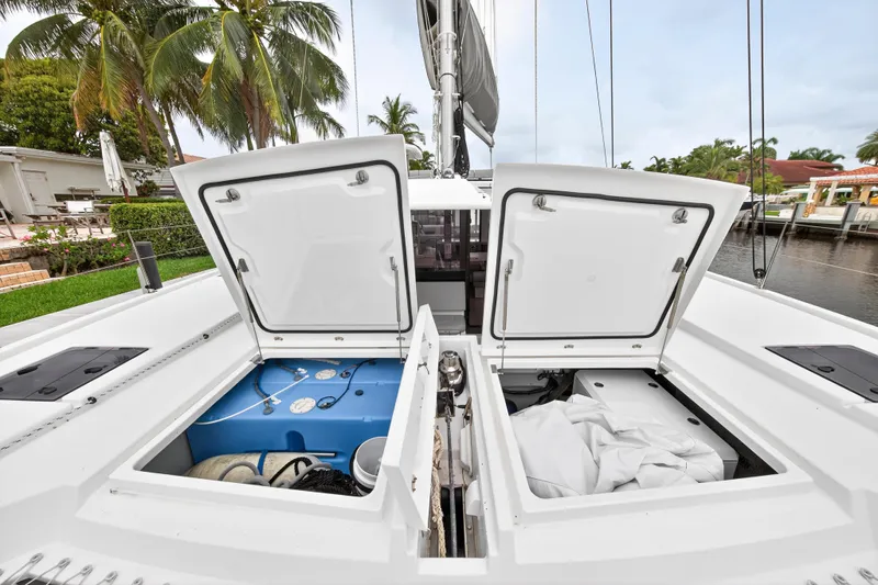 Sundecker Yacht Photos Pics Open storage compartments on a 2021 Leopard 45 catamaran, docked near palm trees.