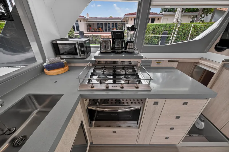 Sundecker Yacht Photos Pics Modern kitchen in a 2021 Leopard 45 yacht with stove, microwave, and blender.