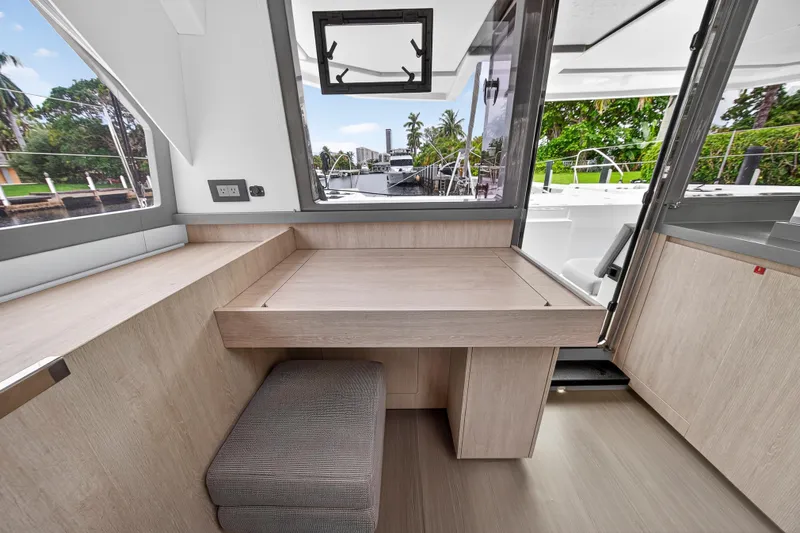 Sundecker Yacht Photos Pics Modern interior of 2021 Leopard 45 yacht with wooden desk and stool.