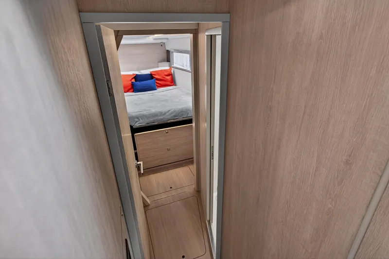 Sundecker Yacht Photos Pics Narrow hallway leading to a cozy bedroom in a 2021 Leopard 45 yacht.