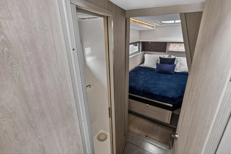 Sundecker Yacht Photos Pics Interior of 2021 Leopard 45 yacht showing cozy bedroom and compact bathroom.