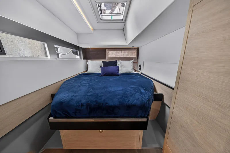 Sundecker Yacht Photos Pics Luxurious bedroom interior of 2021 Leopard 45 yacht with modern design and blue bedding.