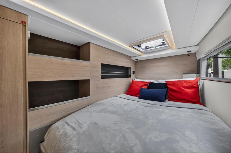 Sundecker Yacht Photos Pics Modern bedroom interior in 2021 Leopard 45 yacht, featuring cozy bed and stylish wood accents.