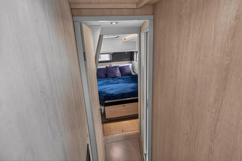 Sundecker Yacht Photos Pics Interior view of 2021 Leopard 45 yacht cabin with cozy bed and wooden finish.