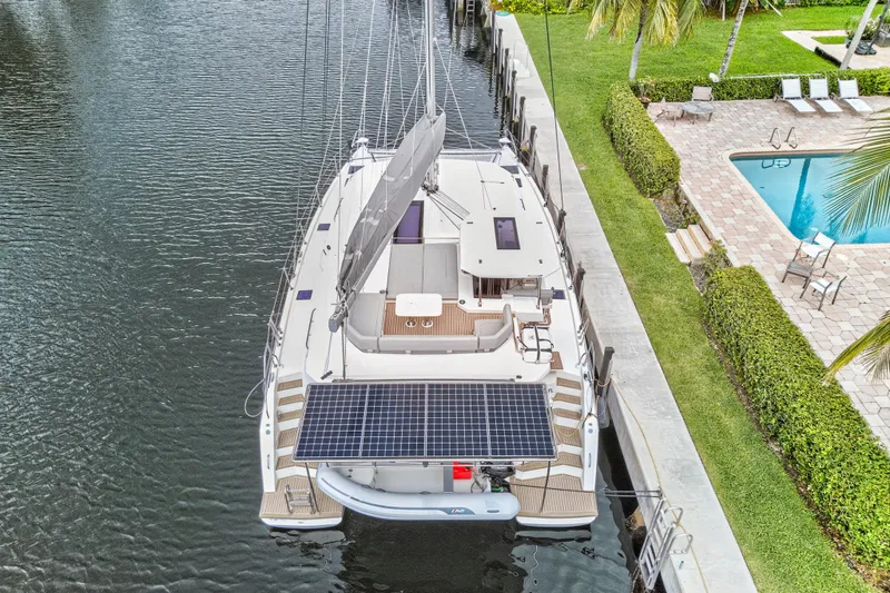 Sundecker Yacht Photos Pics Aerial view of 2021 Leopard 45 catamaran docked by a poolside.