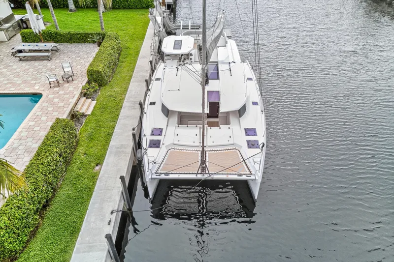 Sundecker Yacht Photos Pics Aerial view of 2021 Leopard 45 catamaran docked beside a luxurious waterfront property.